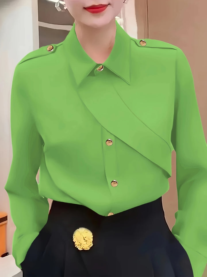 Green blouse with gold buttons worn by a person, against a neutral background