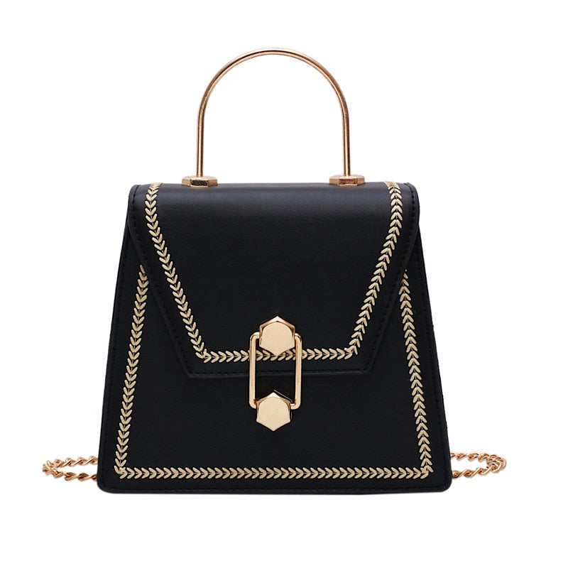 Black mini clutch handbag with gold metal handle, braided trim, and front clasp lock