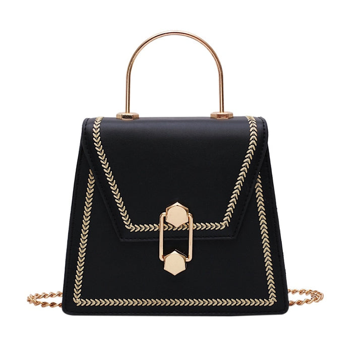 Black mini clutch handbag with gold metal handle, braided trim, and front clasp lock