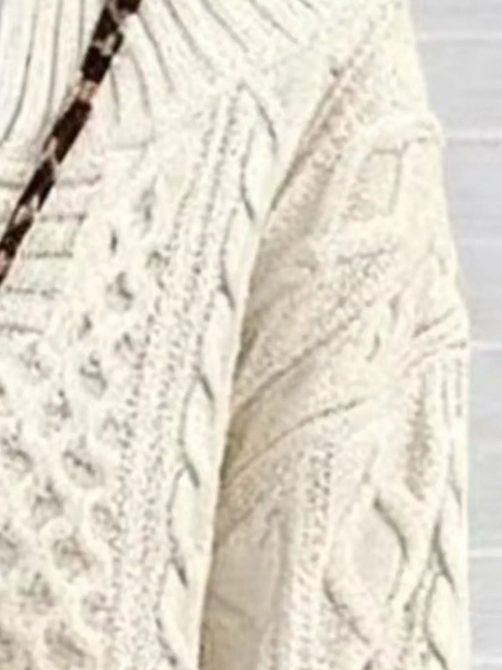 Off-white cable-knit sweater fabric close-up with raised cable stitch texture