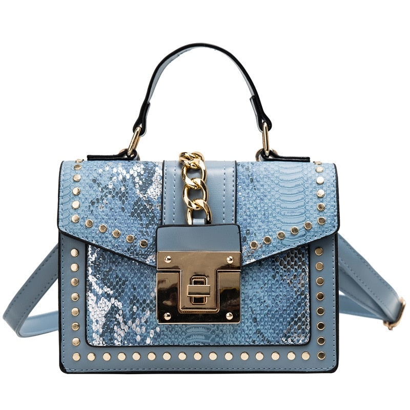 Alligator-texture handbag with chain strap, light blue body, gold studs, front flap lock