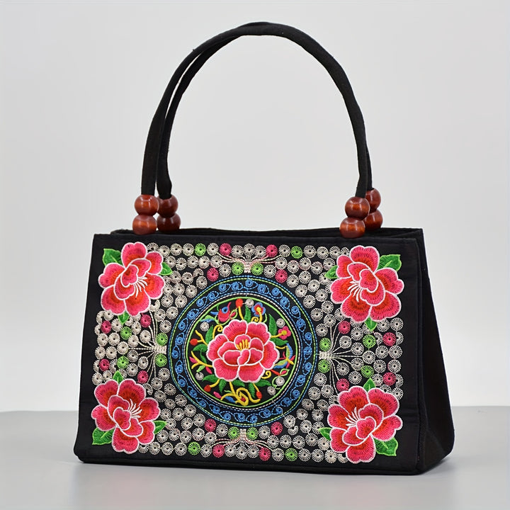 Decorative handbag with floral patterns and beadwork on a white background