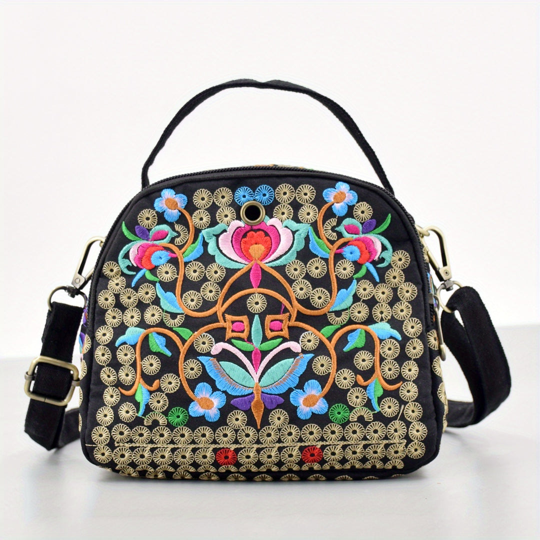 Black handbag with colorful floral embroidery on a white background