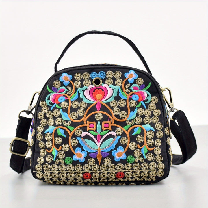 Black handbag with colorful floral embroidery on a white background