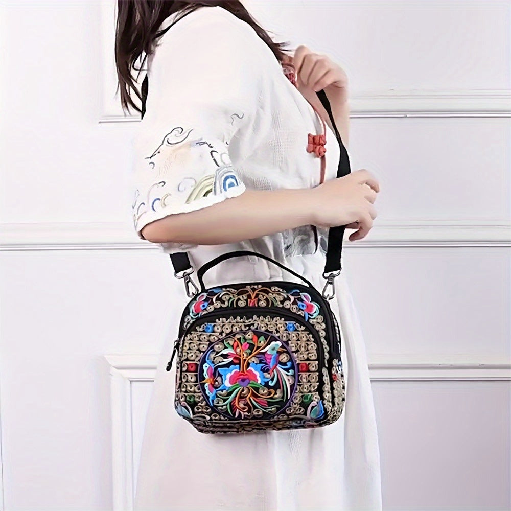Person holding a colorful embroidered handbag against a white background