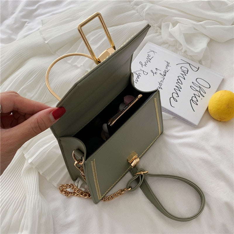 Sage green clutch handbag open with gold zipper, braided trim, and inner pocket