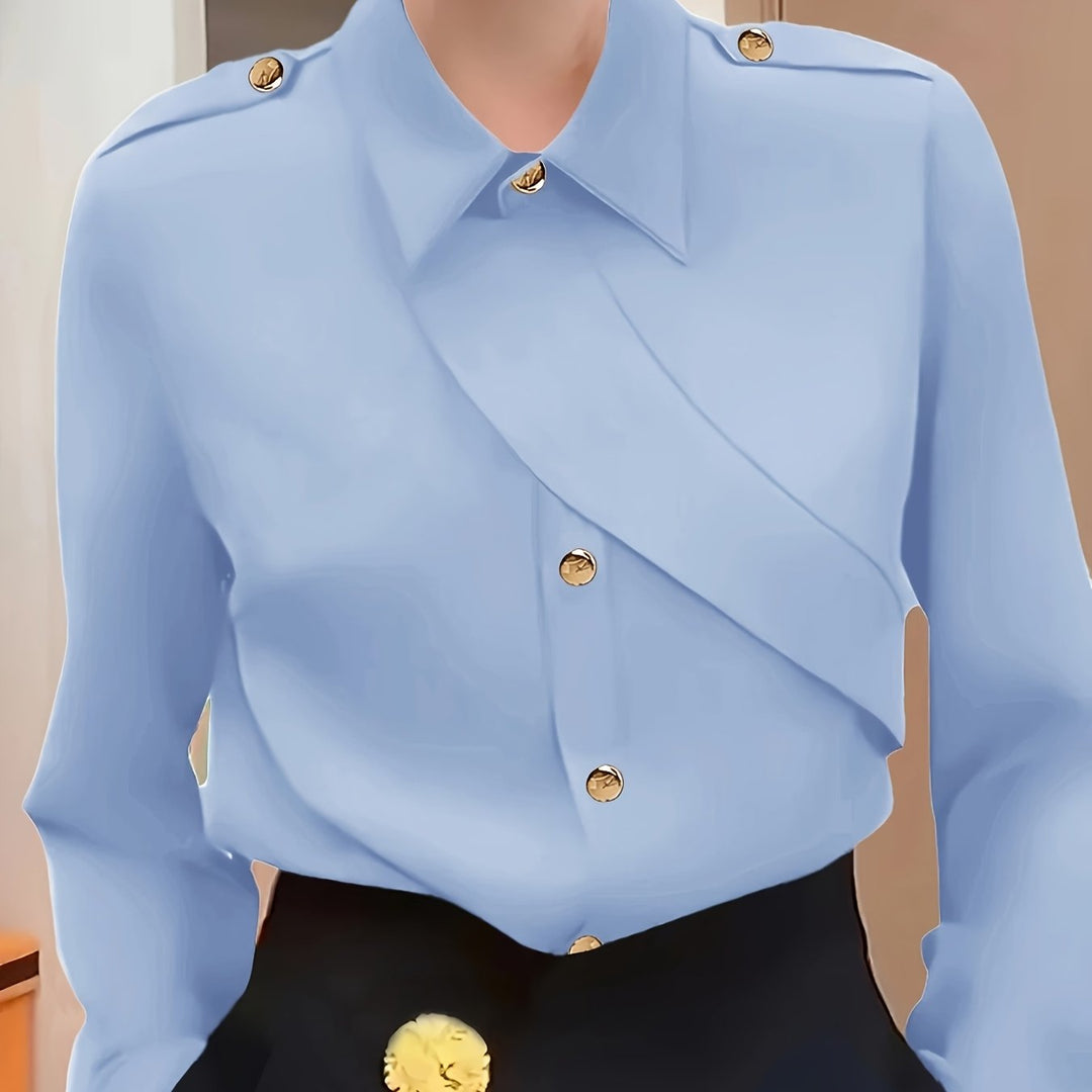 Light blue blouse with gold buttons on a neutral background