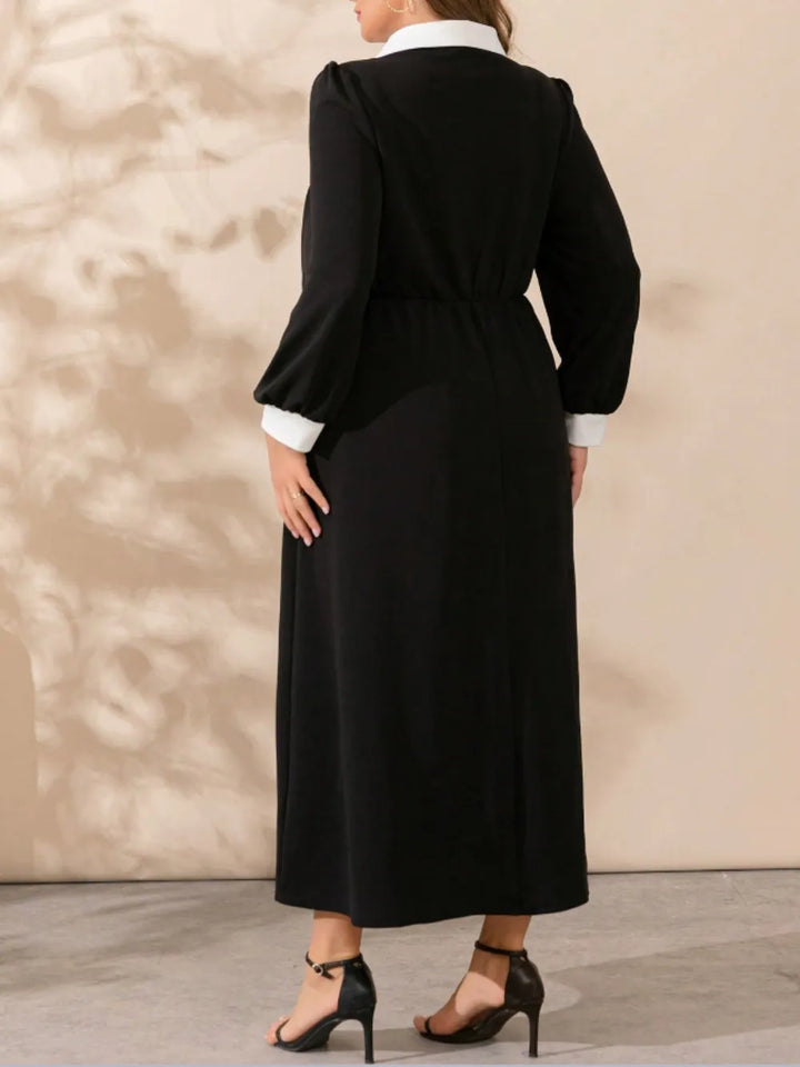 Back view of black long-sleeve midi dress with waist tie and contrast white cuffs