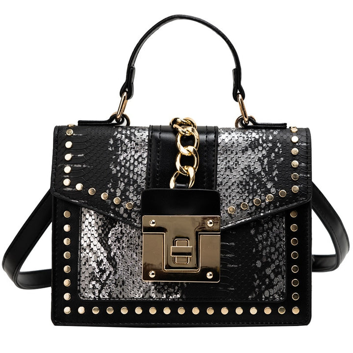 Alligator-texture handbag with chain strap, black and speckled panels, gold studs, flap lock