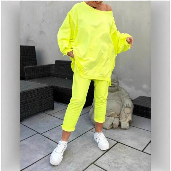 Person wearing a bright yellow outfit with white sneakers on a patio.