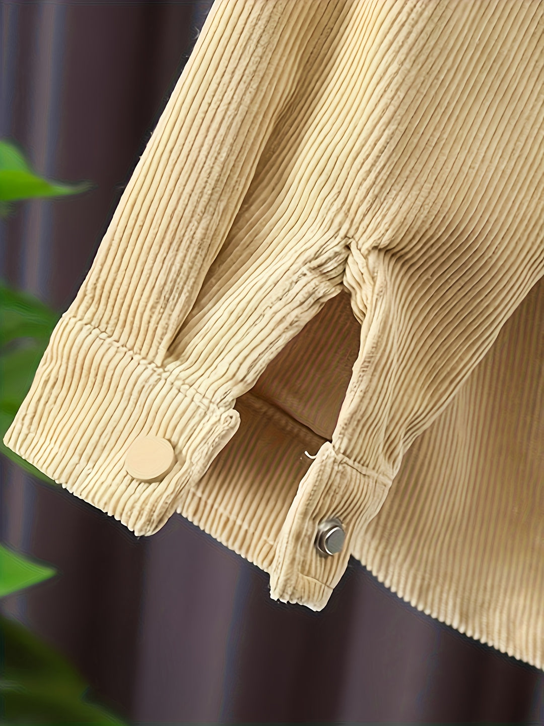 Close-up of beige corduroy jacket with buttons against a blurred background