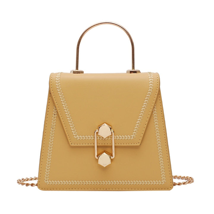 Beige mini clutch handbag with gold metal handle, braided trim, and front clasp