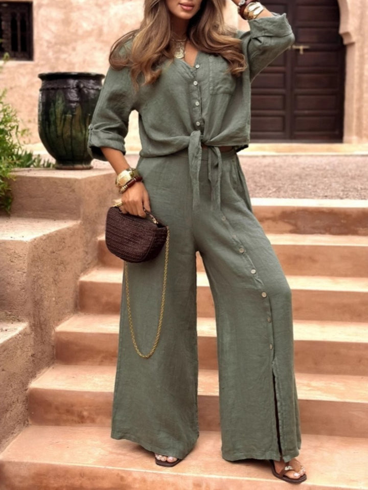 Woman in a green jumpsuit standing on stone steps