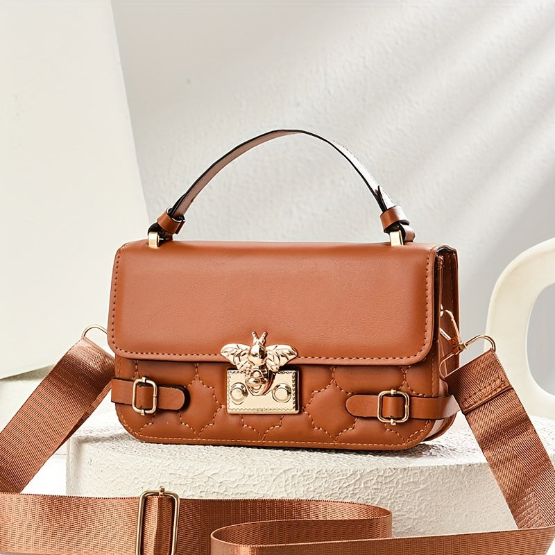 Brown leather handbag with gold accents on a light background