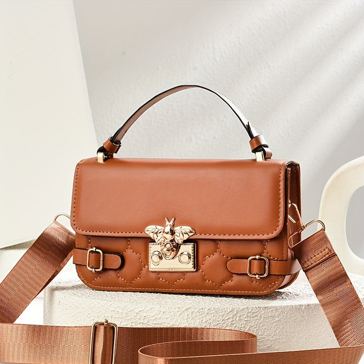 Brown leather handbag with gold accents on a light background