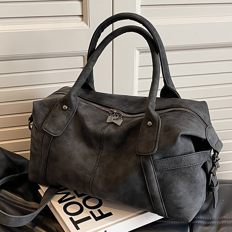 Dark gray handbag on a surface with a neutral background