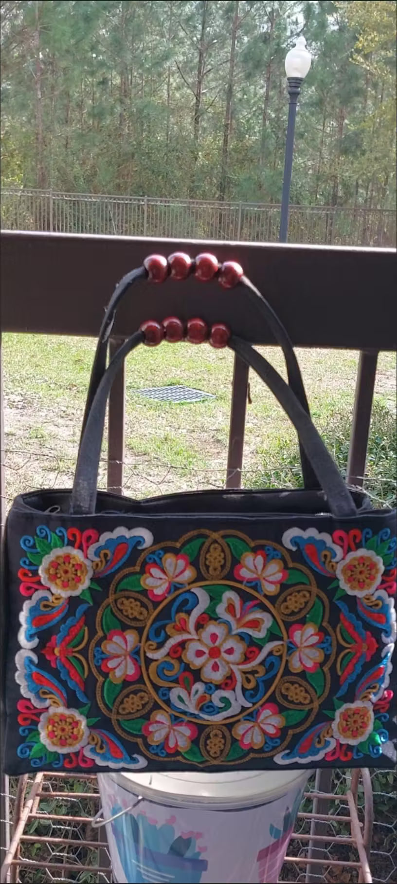 Decorative handbag with colorful patterns on a chair outdoors