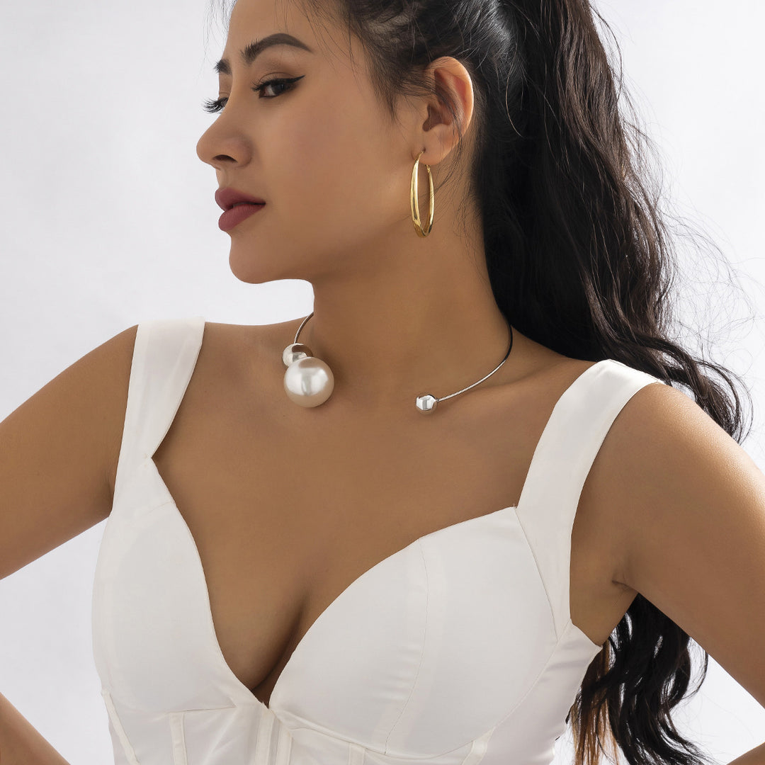 Woman wearing gold hoop earrings and pearl necklace on a white background