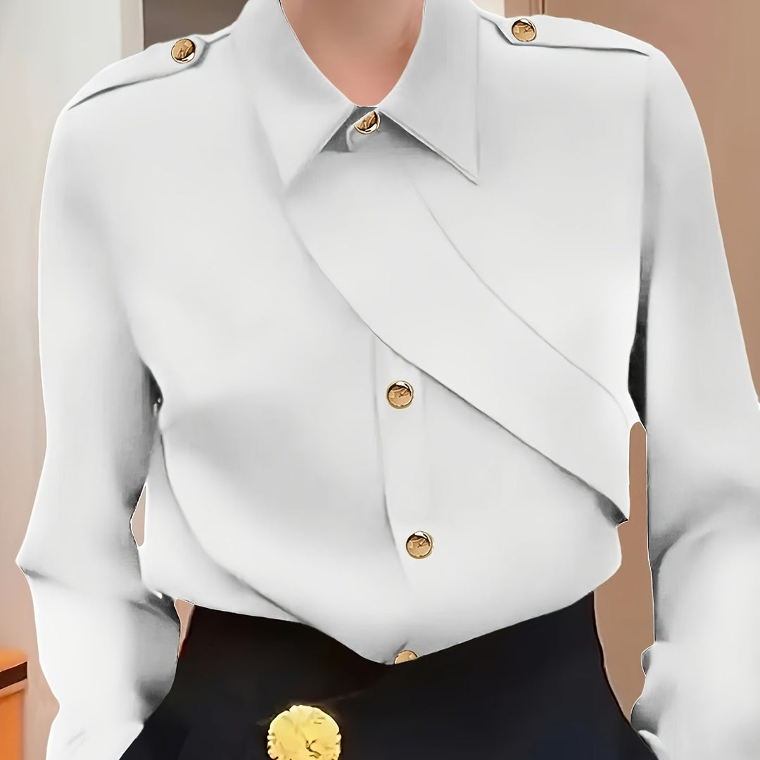 White blouse with gold buttons on a mannequin against a neutral background