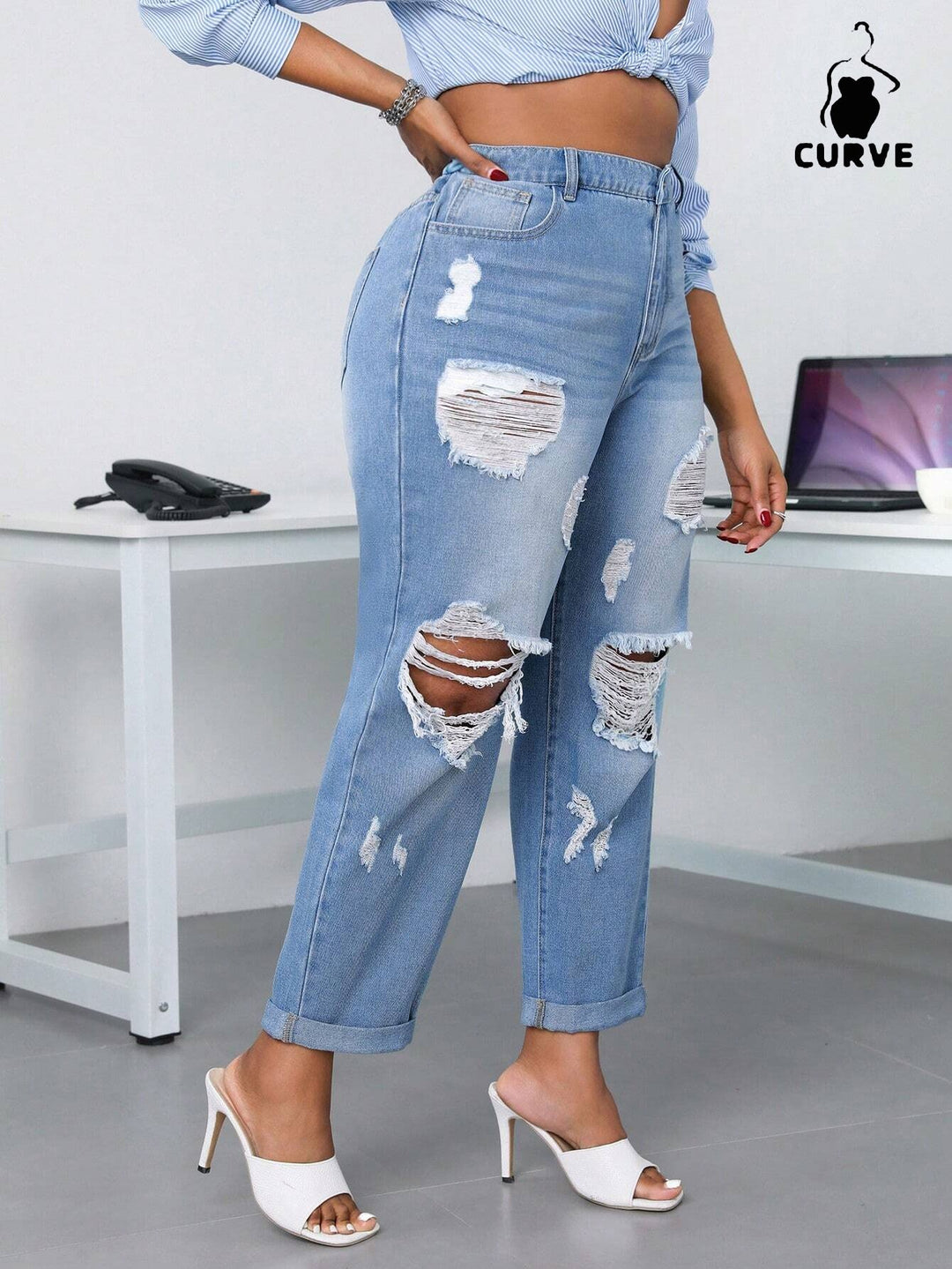 Person wearing ripped blue jeans in an office setting with 'Curve' branding.