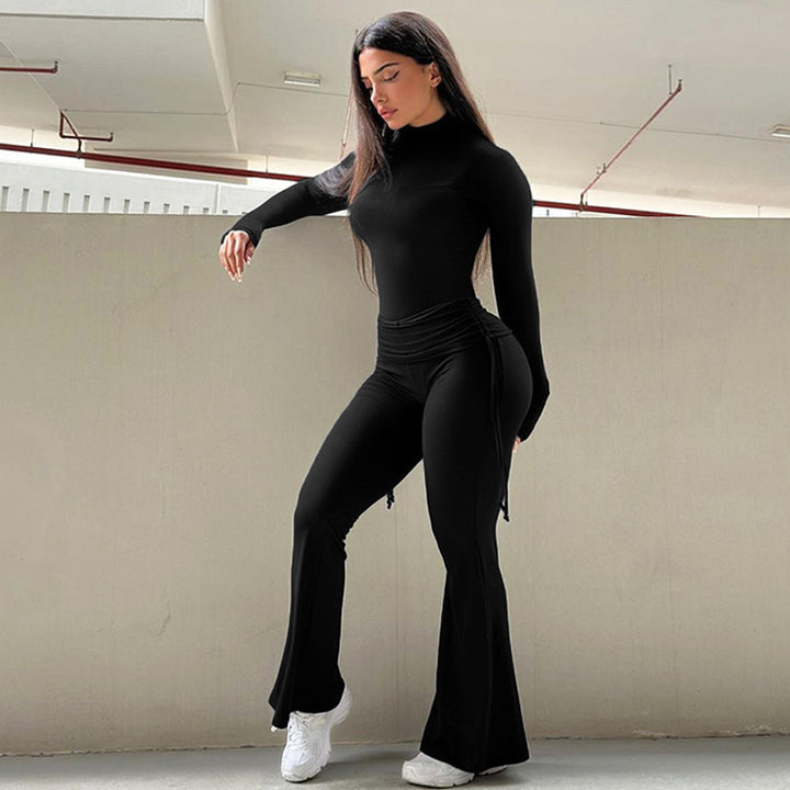 Woman wearing black 2pcs Yoga Set on gray wall.