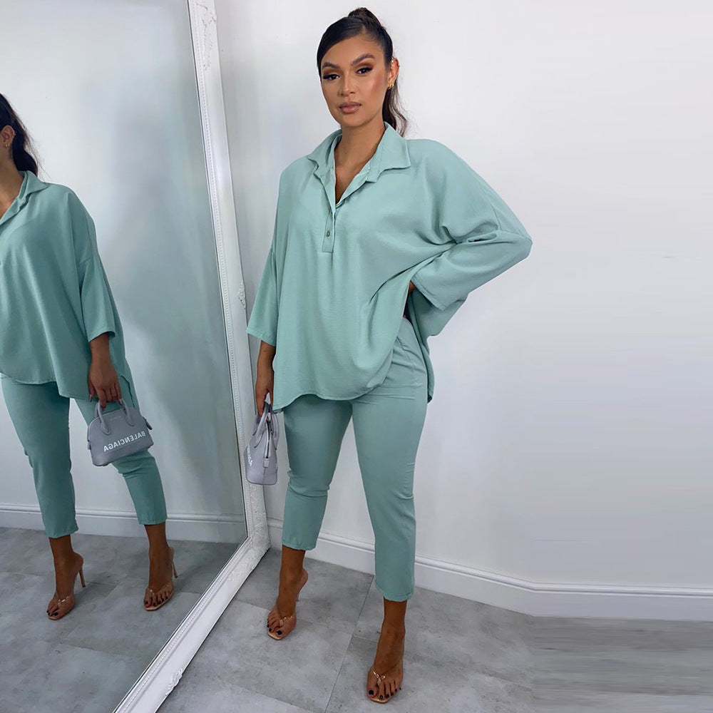 Woman in a teal outfit standing in front of a mirror.