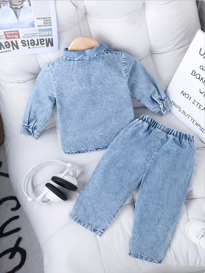 Children's denim outfit on a white surface with newspapers in the background
