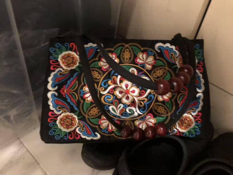 Decorative handbag with colorful embroidery on a plain background