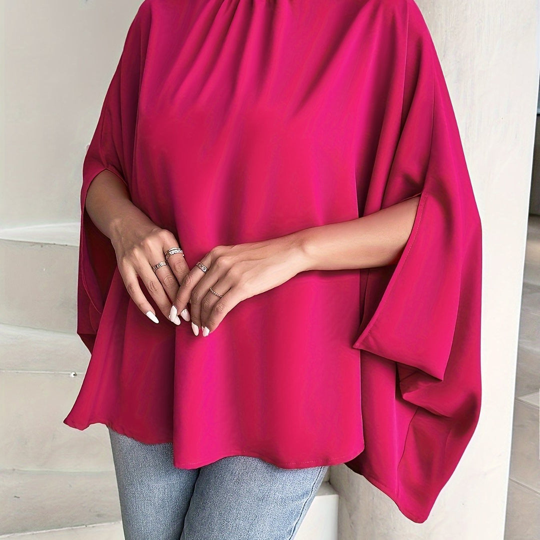Person wearing a bright pink poncho with a neutral background