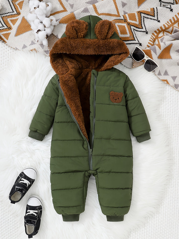 Green baby snowsuit with brown fur hood on a white surface