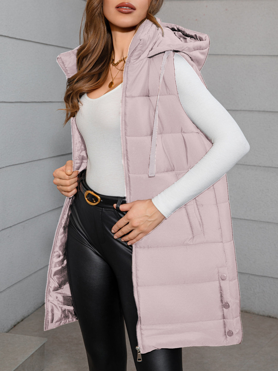 Women's long hooded puffer vest in pale pink, sleeveless with front zipper and drawstring