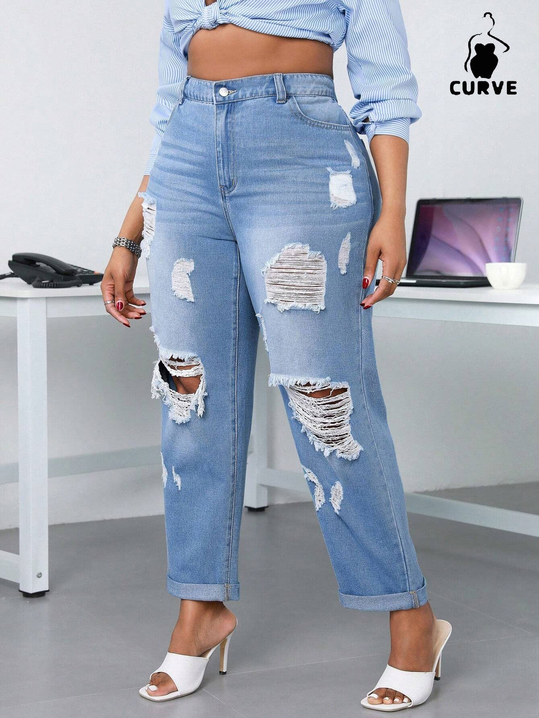 Person wearing ripped blue jeans in an office setting with 'Curve' branding.