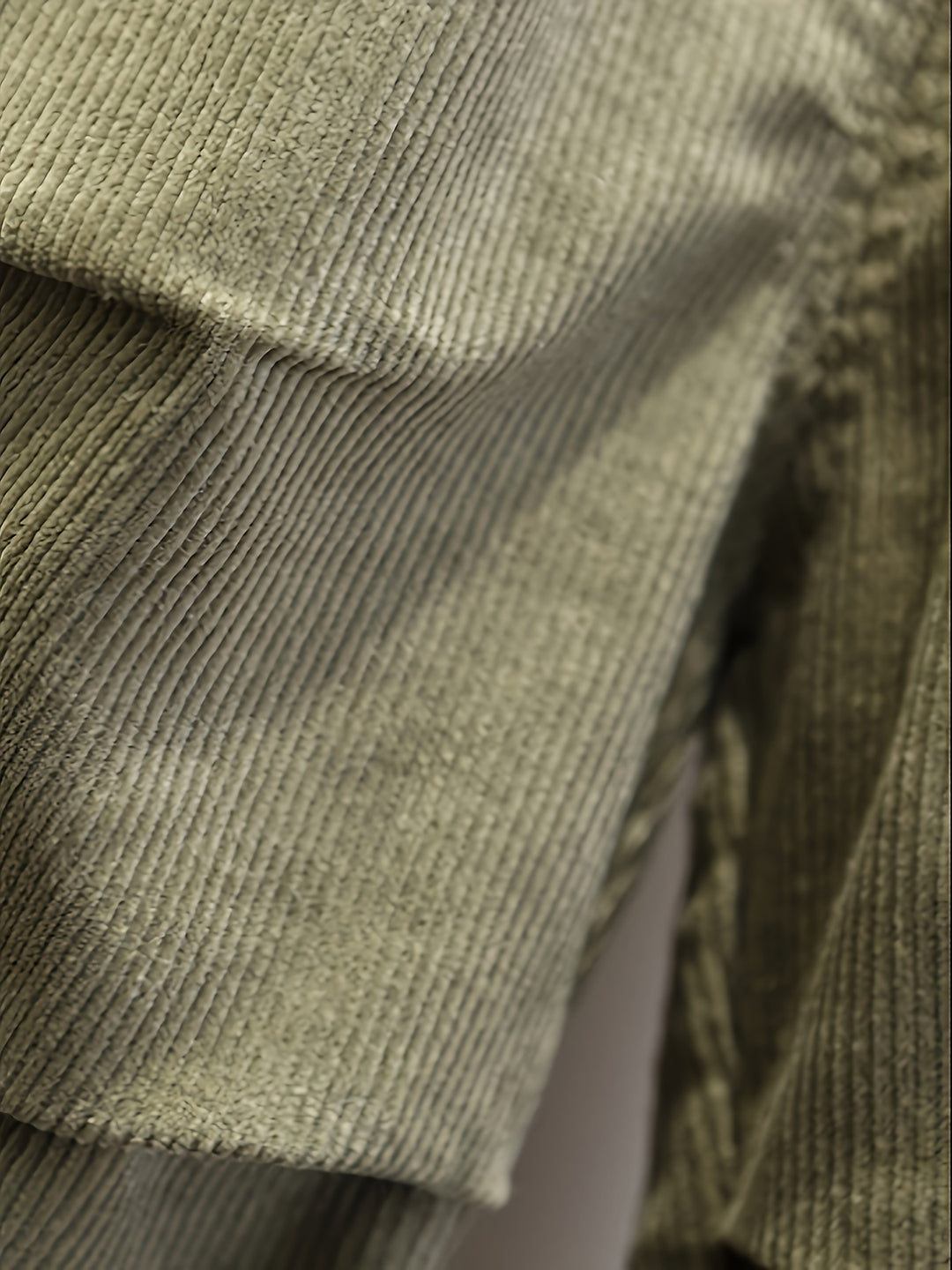 Close-up of a textured green fabric with a patterned background