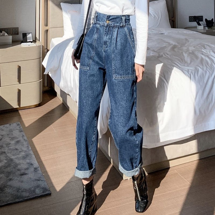 Person wearing blue jeans and black boots in a bedroom setting