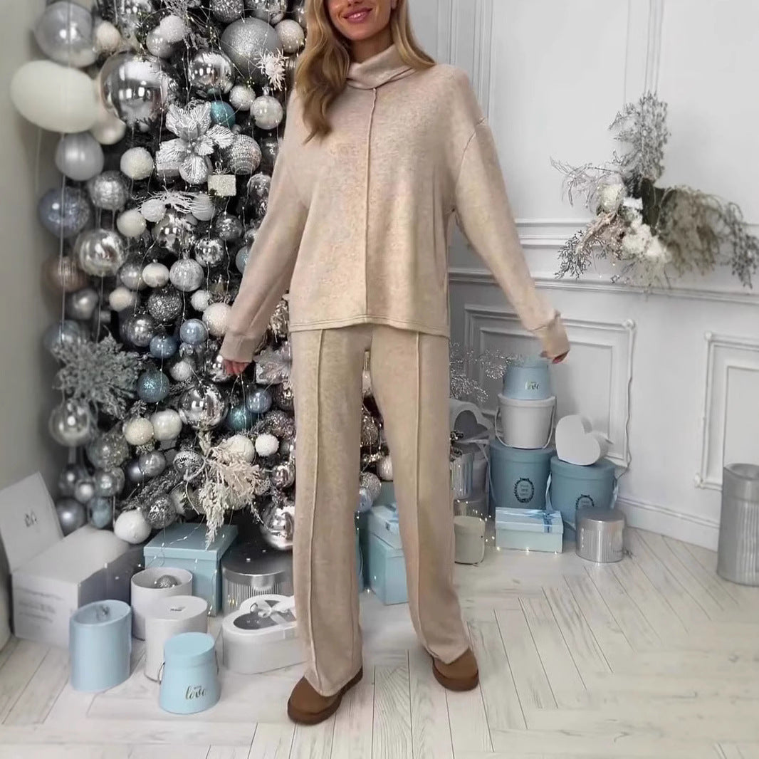 Woman in beige outfit standing in a room with decorative Christmas tree and presents.