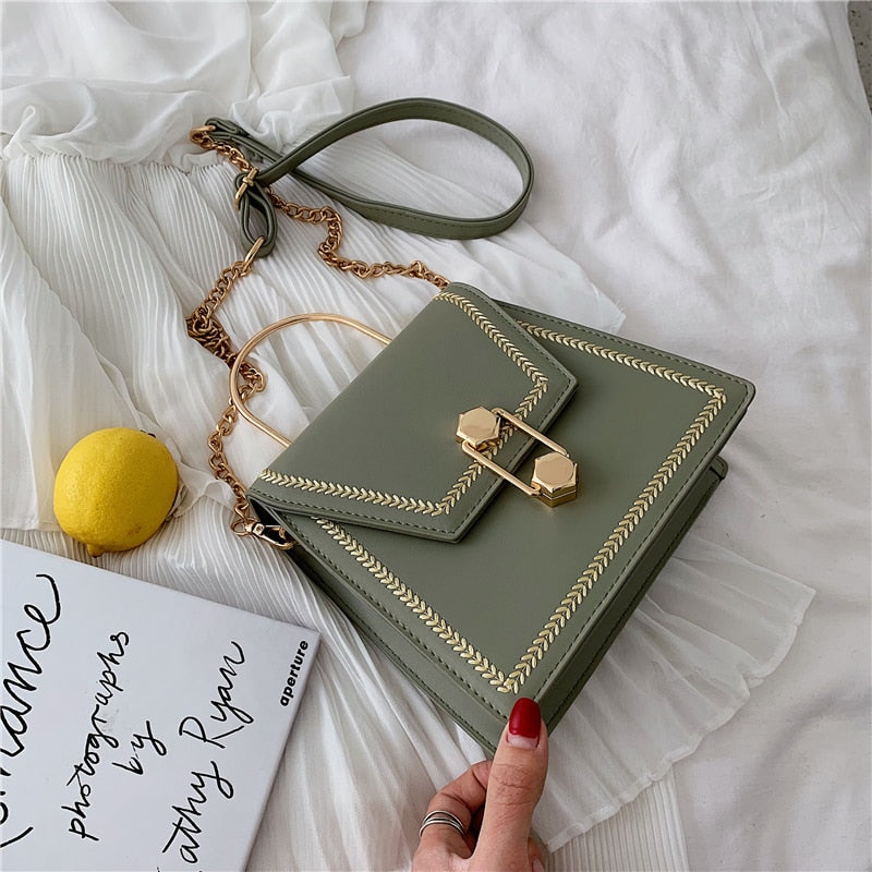 Sage green clutch handbag with gold metal clasp, braided edge trim, and shoulder strap