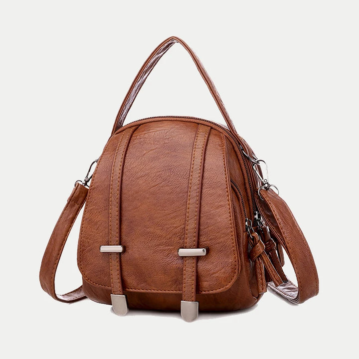 Brown leather backpack with straps on a light gray background