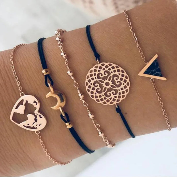 Charms bracelet set with gold-tone chains and blue cord, featuring circular patterned disc