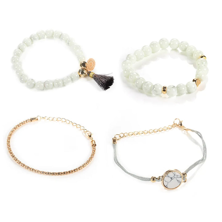 Mixed bracelet set: white beaded bangles, gold-tone chain bracelet, and round marble-look charm