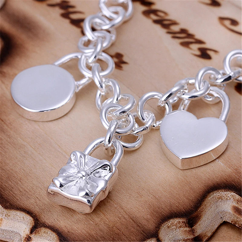 Silver chain bracelet  with  charm pendants on a surface