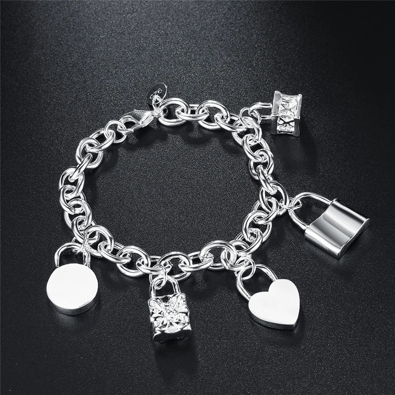 Silver chain bracelet  with  charm pendants on a surface