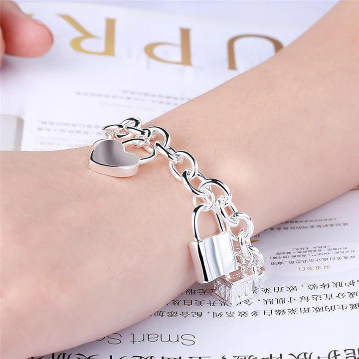 Silver chain bracelet  with  charm pendants on a surface