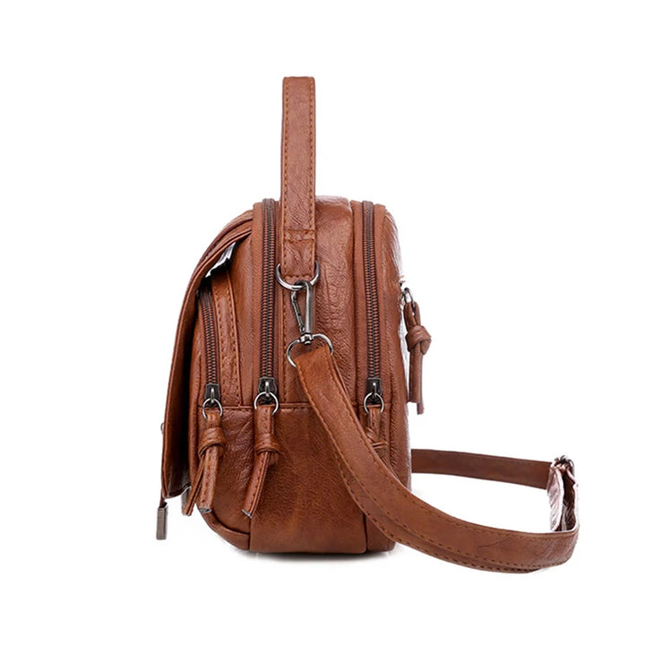 Brown leather backpack with a shoulder strap on a white background
