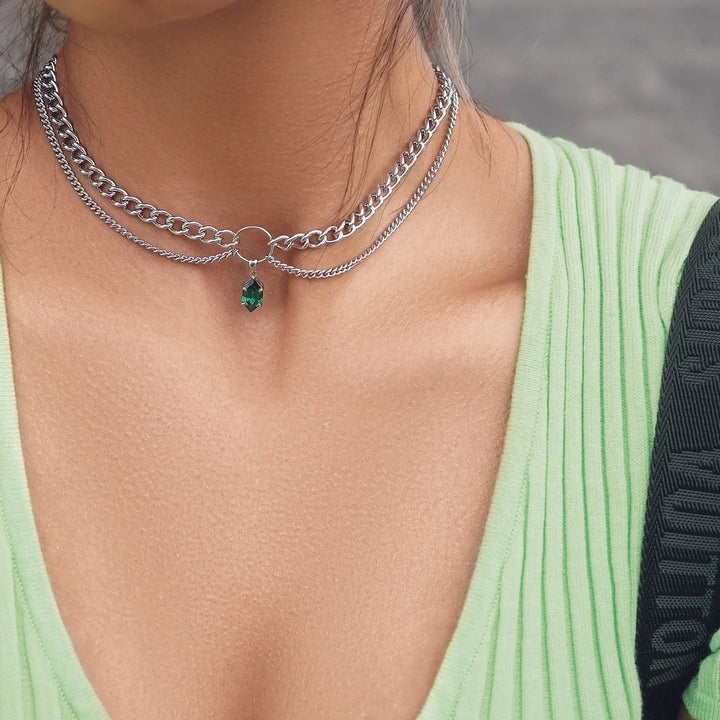 Layered chain necklace with small green faceted gemstone pendant, silver-tone