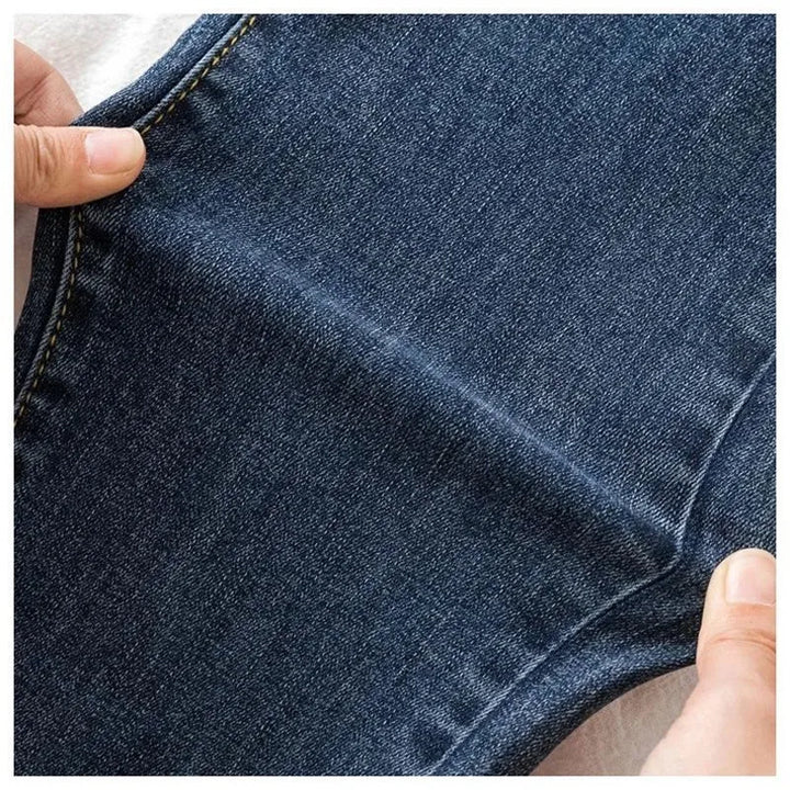 Close-up of blue denim fabric with a hand holding it