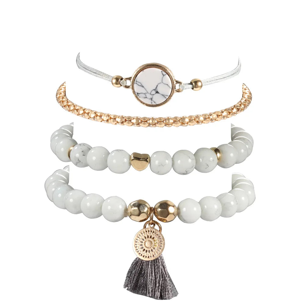 Multi-row bracelet set with white beads, gold-tone toggle accents, and tassel heart charm