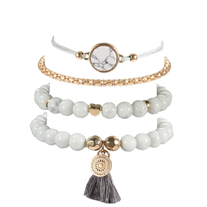 Multi-row bracelet set with white beads, gold-tone toggle accents, and tassel heart charm