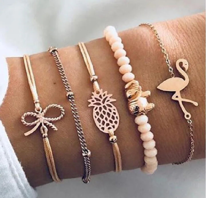 Gold-tone charm bracelet set with butterfly, pineapple, flamingo, and white bead strand