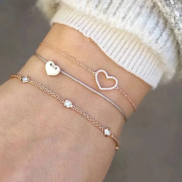 Rose gold-tone chain bracelet set with heart charms and small crystal bead accents