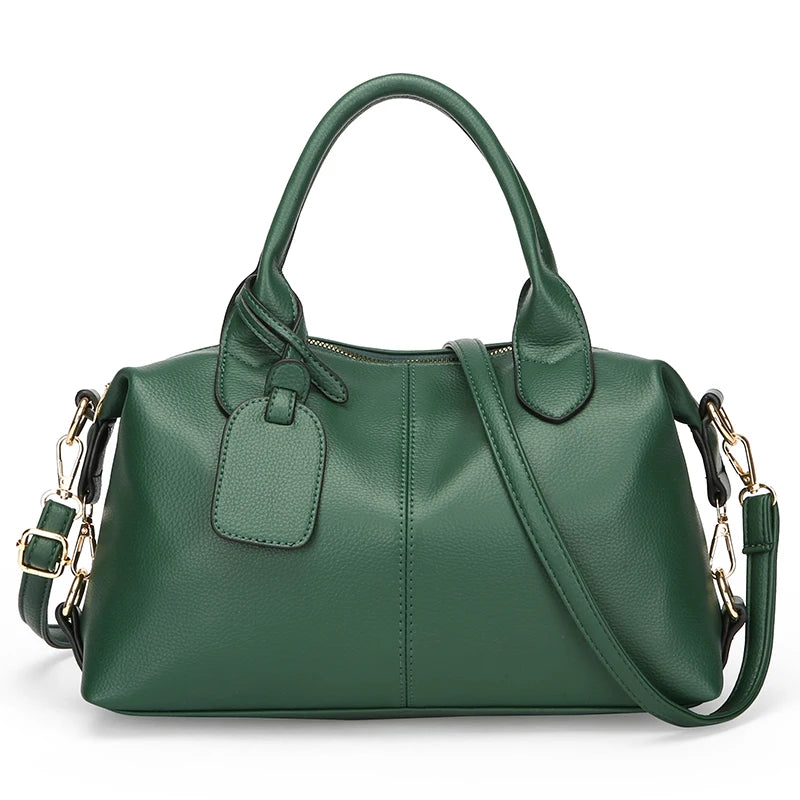Dark green soft leather tote bag with top handles, front luggage tag, and shoulder strap